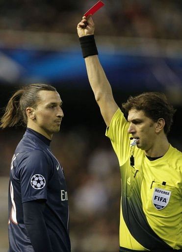 Referee Paolo Tagliavento (R) shows a red card to PSG's Zlatan Ibrahimovic in Valencia on February 12, 2013